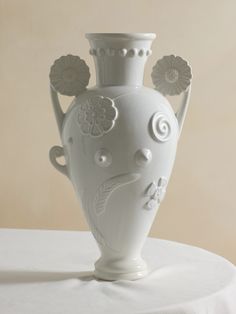 a white vase sitting on top of a table