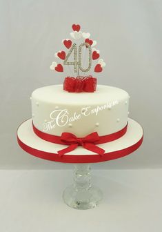 a white cake with red ribbon and hearts on the top is for sale at ebay