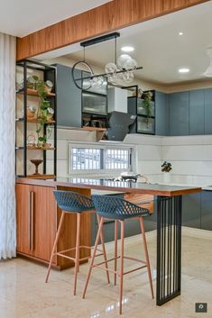 a kitchen with two bar stools next to an island in the middle of it