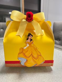 a yellow box with a red rose on top and a princess figure in the middle