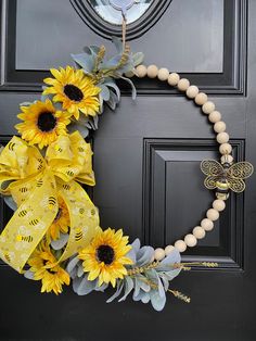 a wreath with sunflowers and bees is hanging on the front door