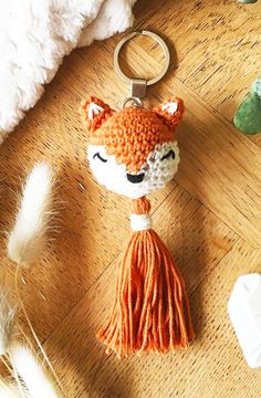 an animal keychain with a tassel hanging from it's side on a wooden floor