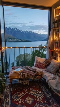 a living room filled with furniture and a book shelf next to a window covered in lights