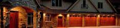 an image of a house that is lit up at night with lights on the garage doors