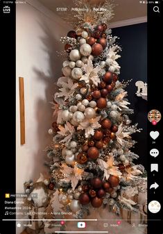 the christmas tree is decorated with silver, gold and white ornaments on it's branches