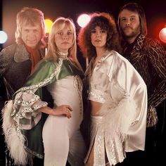 three women and one man are dressed in costumes