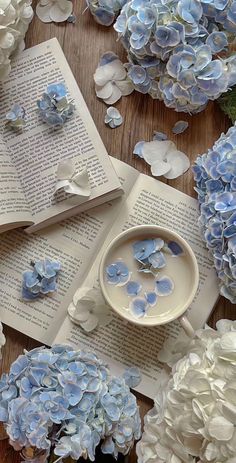 an open book with blue and white flowers next to it