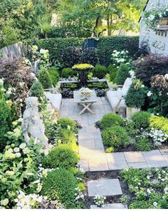 a garden with white flowers and greenery in the center, surrounded by stone steps