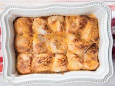 a casserole dish filled with meat and cheese on a red and white checkered table cloth