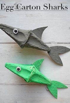 an egg carton shark and a paper fish on a white wooden background with text overlay