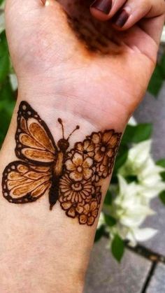 a woman's wrist with a butterfly tattoo on it