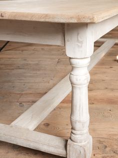 an old white table is sitting on the floor