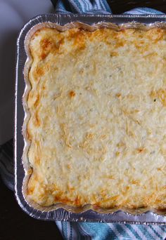 an uncooked casserole is sitting on a blue and white towel