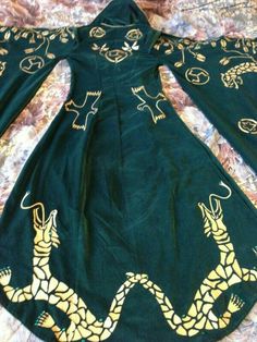 a green dress with gold designs on it