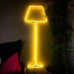 a yellow lamp sitting next to a potted plant