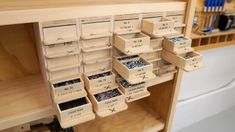 many boxes are stacked on top of each other in front of a shelf filled with screws and nails