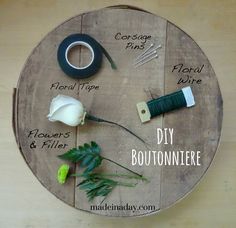 a round wooden table with flowers and scissors on it, labeled by the words diy boutonniere