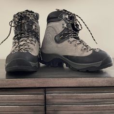 a pair of hiking boots sitting on top of a dresser