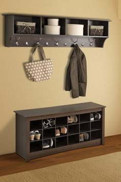 a coat rack with two coats hanging from it and shoes on the shelf next to it