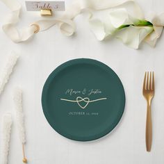 a plate with a heart on it next to two forks and napkins, along with flowers