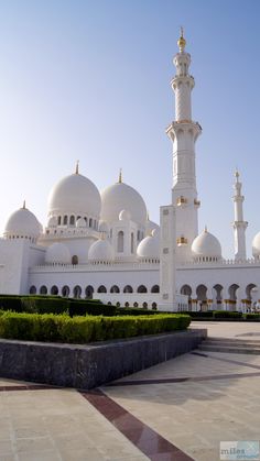 a large white building with many domes and arches on it's sides in the middle of a courtyard