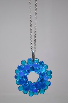 a blue glass beaded necklace hanging from a silver chain