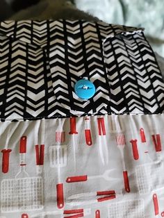 a close up of a pillow on a bed with red and black chevrons