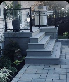 an outdoor patio with steps leading up to a grill