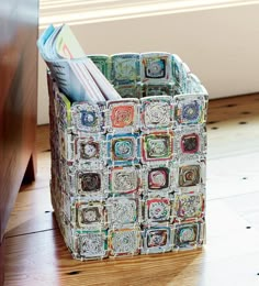 a multicolored storage bin with magazines inside it on a white background, showing the bottom section