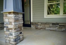 a house with stone pillars in front of it and a window on the far side