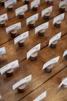 many business cards are placed on a wooden table with wood planks and tapered edges