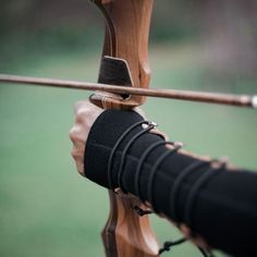 the bow is being held up by someone's hand with an arrow in it