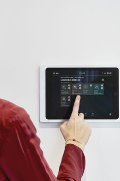 a person pointing at a touch screen on a wall