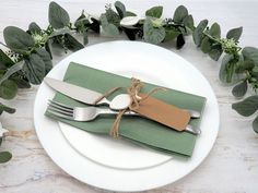 a white plate topped with green napkins and silverware