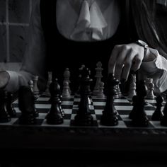 a woman is playing chess in the dark