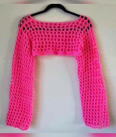 a pink sweater hanging on a hanger