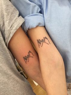 two people with matching tattoos on their arms