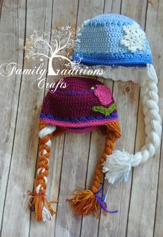 two crocheted hats with braids and flowers on them sitting on a wooden surface