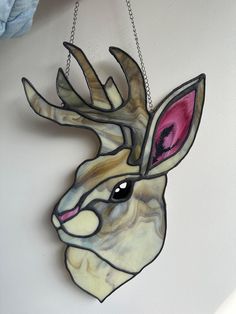 a wooden deer head hanging from a chain