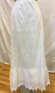 "1890s, one size drawstring full length linen petticoat. Bottom ruffle is deep with embroidered pointed edged lace. Petticoat had back opening and is fastened with long cotton drawstring. Measurements: waist to hem 34\" Width at mid section 46\" Width at bottom 72\" Height if ruffel 8\" Condition excellent" Vintage Fitted Wedding Bottoms, Regency Style Ruffled Petticoat For Daywear, Fitted Long Cotton Petticoat, Fitted Cotton Long Petticoat, Fitted Ruffled Petticoat For Daywear, Fitted Ruffles Petticoat For Daywear, Vintage Bottoms For Summer Wedding, Fitted Ruffle Petticoat For Daywear, Victorian Cotton Wedding Dress With Ruffles