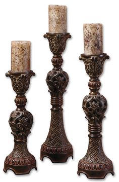 three ornate metal candlesticks with marble tops