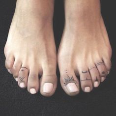 two feet with different symbols on them and one has a crown tattooed on the toe