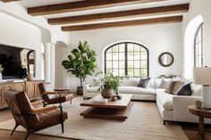 a living room filled with furniture and a flat screen tv on top of a wooden table