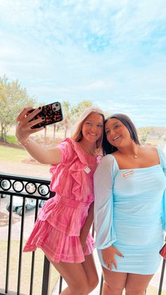 two women standing next to each other on a balcony