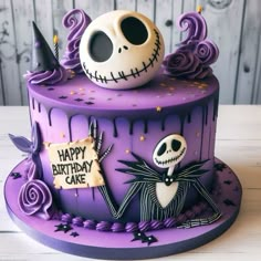 a birthday cake decorated with purple icing and spooky decorations