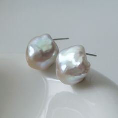 Mini White Baroque Pearl Stud Earrings A pair of stunning natural freshwater baroque pearls like sea shell form, with blue pink lustre, paired with silver ear pins.  The unique organic shapes of the baroque pearls ensure that no two earrings are identical, offering you a truly one-of-a-kind piece of jewelry. Measuring at a versatile size, these stud earrings are ideal for both day-to-day wear and special occasions.  MATERIAL: Sterling Silver, Natural Baroque Pearl PEARL SIZE: Approx. 14*15mm  *Due to hygiene-related reasons, this piece may not be returned.* *Natural materials like pearls have natural growth marks and imperfections, which are their individual beauty and character, ensuring that no two pieces are alike and not considered as quality issues.* ---------- 🚚 ALL ABOUT SHIPPING ✈ Pearl White Baroque Pearl Bridal Earrings, Wedding Baroque Pearl Earrings In Pearl White, White Baroque Pearl Earrings, Round Shape, White Baroque Pearl Bridal Earrings, White Baroque Pearl Bridal Earrings For Wedding, Silver Baroque Pearl Earrings For Wedding, Pear-shaped Baroque Pearl Earrings For Weddings, Delicate Pear-shaped White Bridal Earrings, Pearl Earrings Wedding