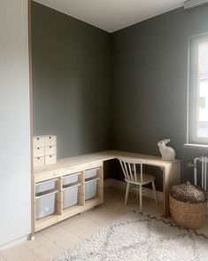 an empty room with a desk, chair and storage bins