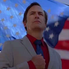 a man standing in front of an american flag