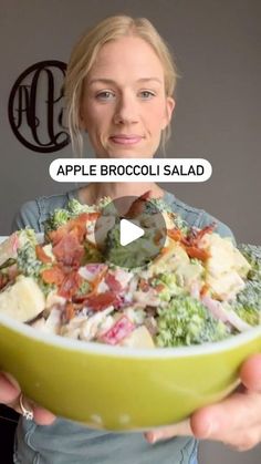 a woman holding a green bowl full of food with the words apple broccoli salad