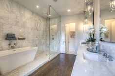 a large white bath tub sitting next to a walk in shower